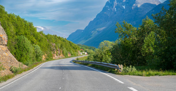 istock Winding asphalt road in green forest under high hill 2078201281
