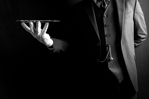Butler in Suit and White Gloves Holding Silver Serving Tray