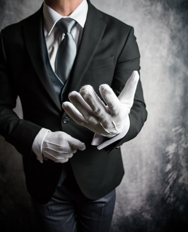 Butler or Hotel Concierge in Formal Suit and White Gloves Offering Helping Hand