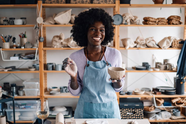 istock Interracial craftswoman with earthenware in hands at pottery class. 2078239681