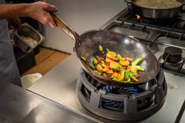 istock Cook stir frying vegetables and prawns in a wok 2078241411