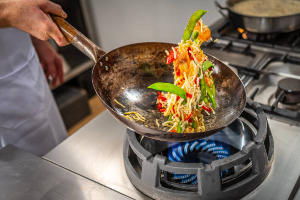 istock Cook stir frying vegetables and prawns in a wok 2078241422