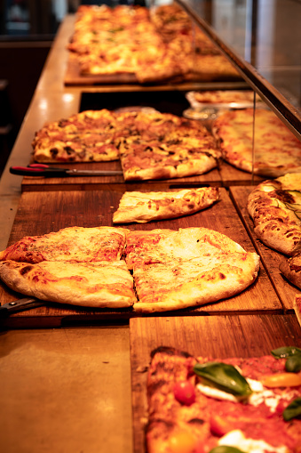 Venice, Veneto - Italy - 06-09-2021: Delicious variety of pizzas showcased on wooden boards in a Venetian eatery