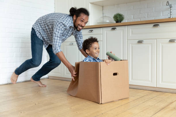 istock Little African boy enjoy playtime ride sit inside carton box 2078269290