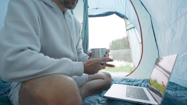 istock Digital nomad working in tent while camping in nature. 2078271546
