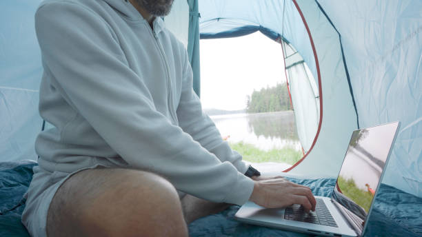 istock Digital nomad working in tent while camping in nature. 2078271551