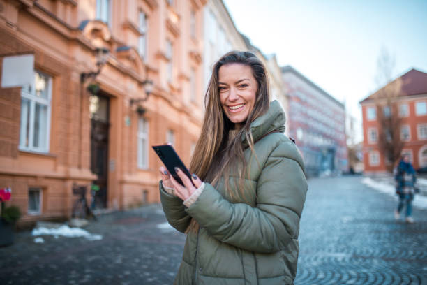 istock Smiling Caucasian Woman Using Smartphone in Urban Setting 2078275938