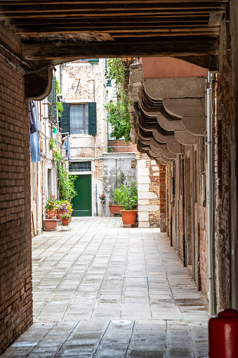 Venice, Veneto - Italy - 06-10-2021: Stone-paved passage under archways in the tranquil backstreets of Venice