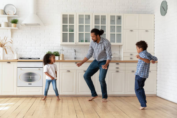 istock Active African father and cute children dancing in the kitchen 2078305304