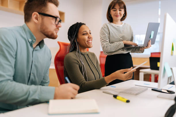 istock Friendly female mentor explaining internes or new employees online task pointing at computer screen. African businesswoman supervisor teaching young woman 2078313392