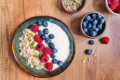 Oatmeal porridge bowl with berry fruits. Bowl of yogurt.