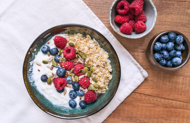 Oatmeal porridge bowl with berry fruits. Bowl of yogurt. stock photo