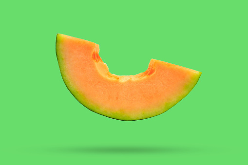 cantaloupe melon slices isolated on green background