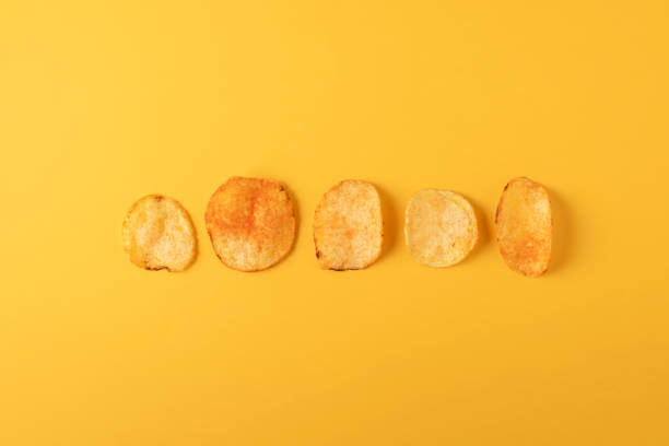 istock Potato chips on yellow background. Flat lay, top view. 2078330791