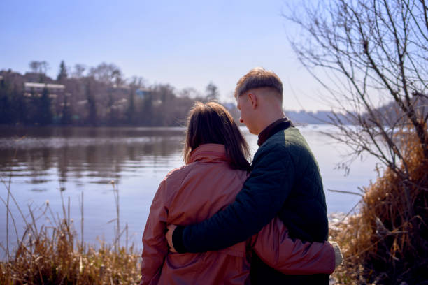 young couple looks at the spring river