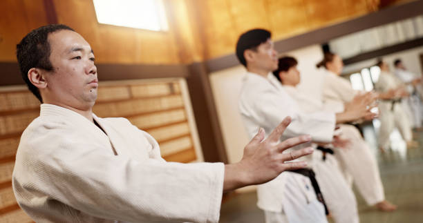istock Aikido class, group and fight for martial arts, strike or together for combat at training, gym or dojo. Japanese people, students or sensei for exercise, workout or fitness with zen, conflict or club 2078356157