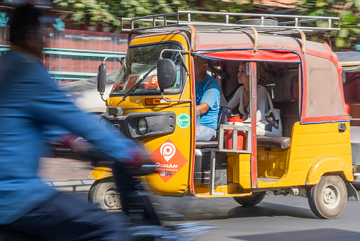Phnomh Penh, Cambodia on Feb 24, 2024: riding a Tuk Tuk in Cambodia's capital is a great experience for locals and tourists alike ; Tuk Tuks are available at every corner: they are a very convenient, speedy and affordable way of transport