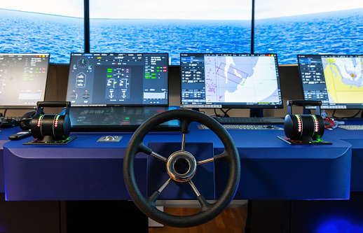Modern ship control panel with steering wheel and engine accelerators. The captain bridge equipment as a part of marine navigation simulation system