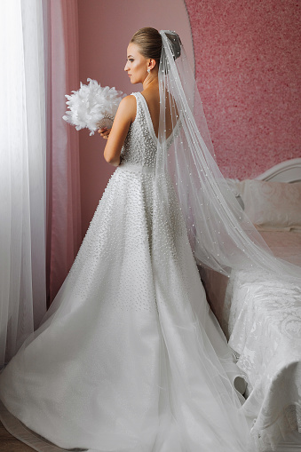 portrait of a beautiful girl in a wedding dress. Fashion, glamour, concepts. The morning of the bride, the bride dresses and prepares for the wedding ceremony