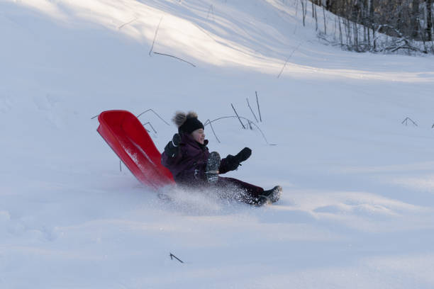istock A little girl fell off her sled while sliding down a hill in winter. 2078378131