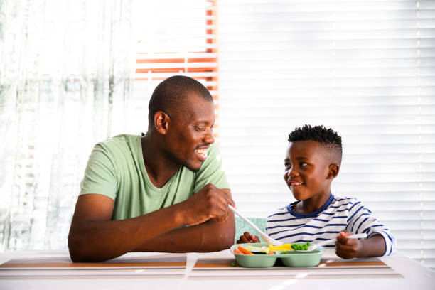 istock Front view father with son eating healthy lunch 2078378690