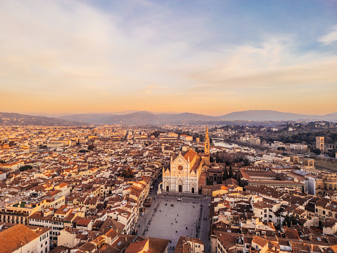 Aerial view of Florence's skyline with Basilica di Santa Croce at sunset. Flying over Florence city in Tuscany, Italy.