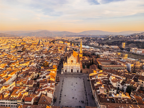 Aerial view of Florence's skyline with Basilica di Santa Croce at sunset. Flying over Florence city in Tuscany, Italy.
