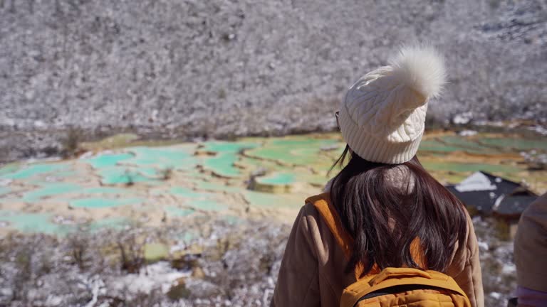 Young female tourist taking a photo of  Huanglong National Park the landmark and popular attractions in Sichun, China