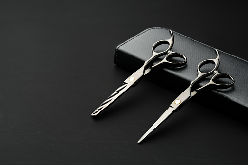 Hairdressing scissors with case on a black background studio shot