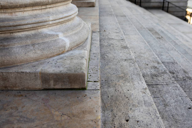 Elegant Caucasian mature couple in their early 50's sitting together on stone steps at a classic looking building facade.