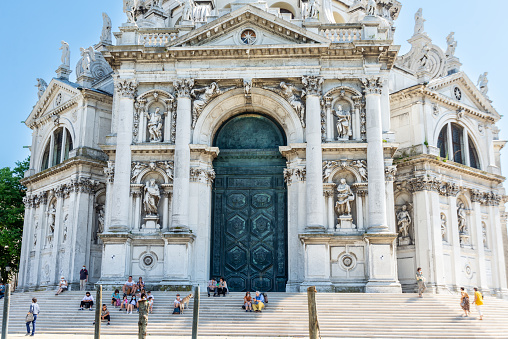 Venice, Veneto - Italy - 06-10-2021: Tourists rest on the steps of the ornate Santa Maria della Salute