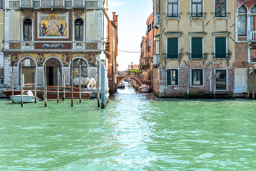 Venice, Veneto - Italy - 06-10-2021: Palazzo Salviati's intricate mosaics stand out along a serene Venice canal