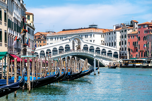 Venice, Veneto - Italy - 06-10-2021: Veniceâs iconic Rialto Bridge, adorned with shops, spans the bustling Grand Canal