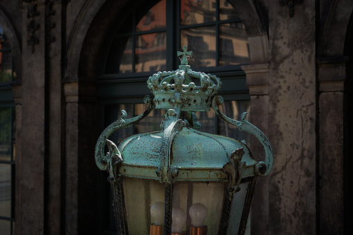 An old metal lantern, historical building exterior, dark colors