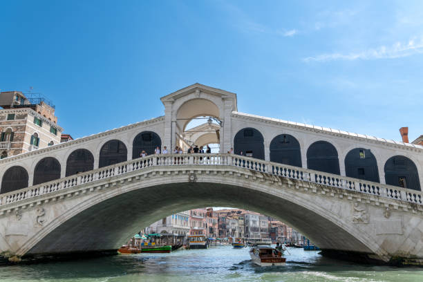 watertaxi passing under venice's historic rialto bridge - market rialto bridge venice italy italy imagens e fotografias de stock