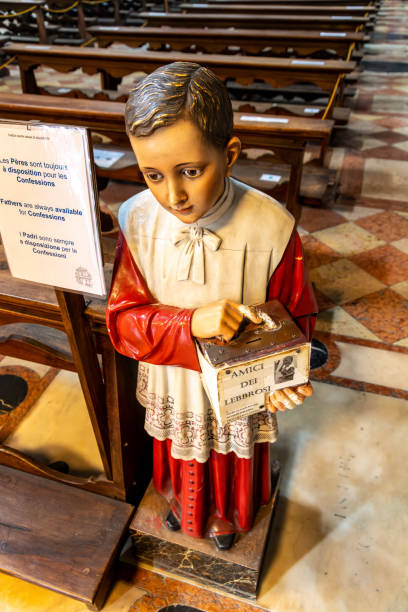 Venice, Veneto - Italy - 06-10-2021: Statue of a boy holds a charity box for 'Amici dei Lebbrosi' inside a church
