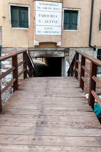 Venice, Veneto - Italy - 06-10-2021: Entrance to the Venetian Ghetto over a wooden bridge and walkway