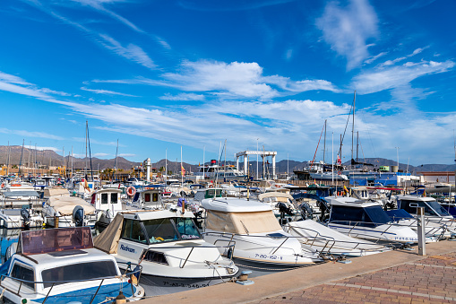 Puerto de Mazarron, Murcia - Spain - 01-18-2024: Diverse boats and yachts crowd the marina of Puerto de Mazarron under a blue sky
