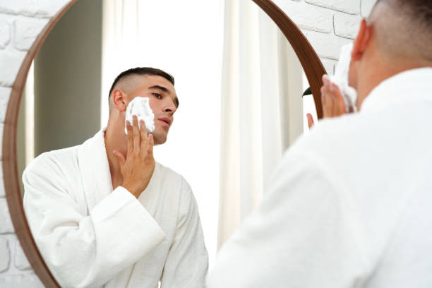 istock Reflection of a young man shaving in bathroom mirror close up 2078474528