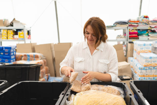 istock Volunteer woman preparing donation boxes for people. 2078480637