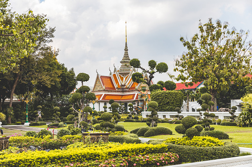 Serene landscape of a beautifully manicured temple garden under a cloudy sky in Thailand - Tranquil temple garden in Bangkok