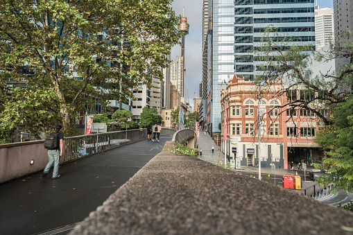Sydney, NSW, Australia, February 19th 2024. General view of a people walking on a pathway framed by skyscrapers and historic buildings.