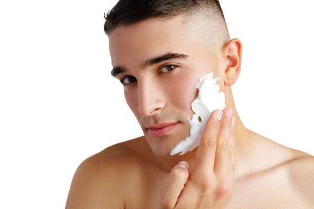 istock Young handsome man applying shaving foam against white background 2078496129
