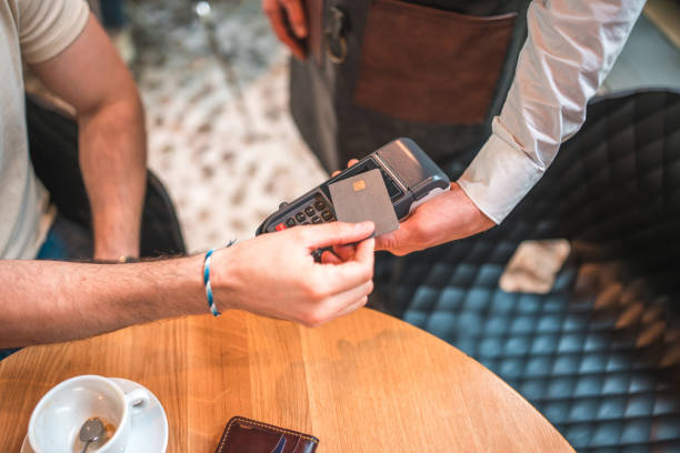 istock Hispanic Male Using Contactless Payment Method with a Credit Card in a Modern Coffee House 2078497099