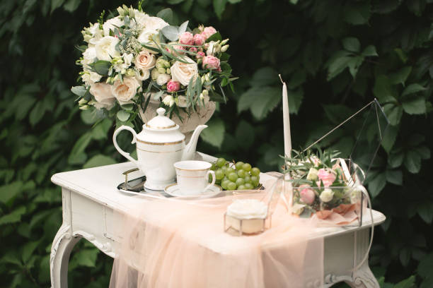 Romantic photo zone for the bride's wedding day gatherings. Table, flowers and rose petals in the forest.