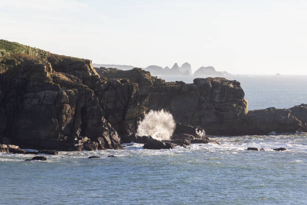 istock A rocky shoreline with a large wave crashing into the rocks 2078513421