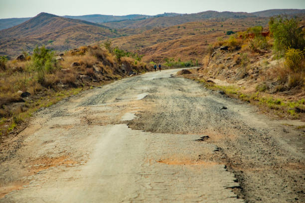Road from Morondava to Antsirabe through empty grassland and village in central Madagascar