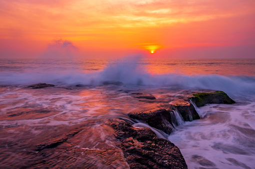 A sunrise seascape under a stormy sky on the east coast of Tasmania in Freycinet National Park.