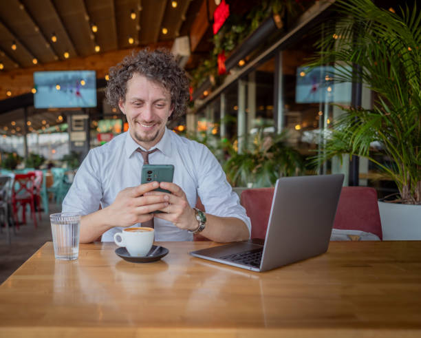istock Businessman using smart phone and drinking coffee in cafe 2078540714