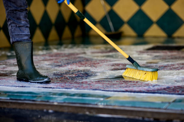 Closeup of Man hand using brush to clean the tile in the bathroom Protection Gloves and Plastic Brush, household Chores, Cleaning the Toilet Bowl at Home.